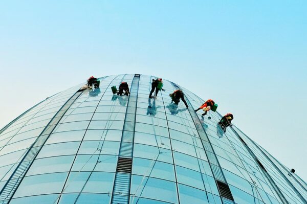 6 Window Washers on Tall Building with Sky