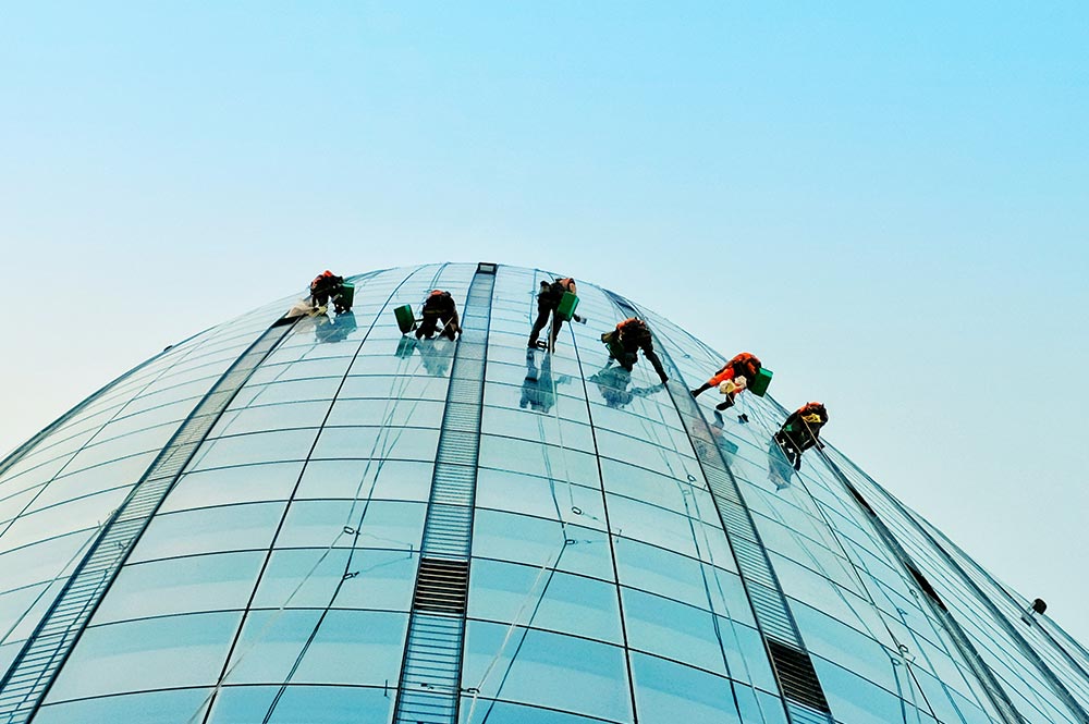6 Window Washers on Tall Building with Sky